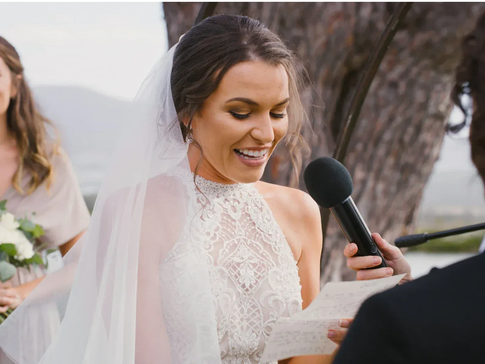 Bride reading her vows during a wedding ceremony outdoors.